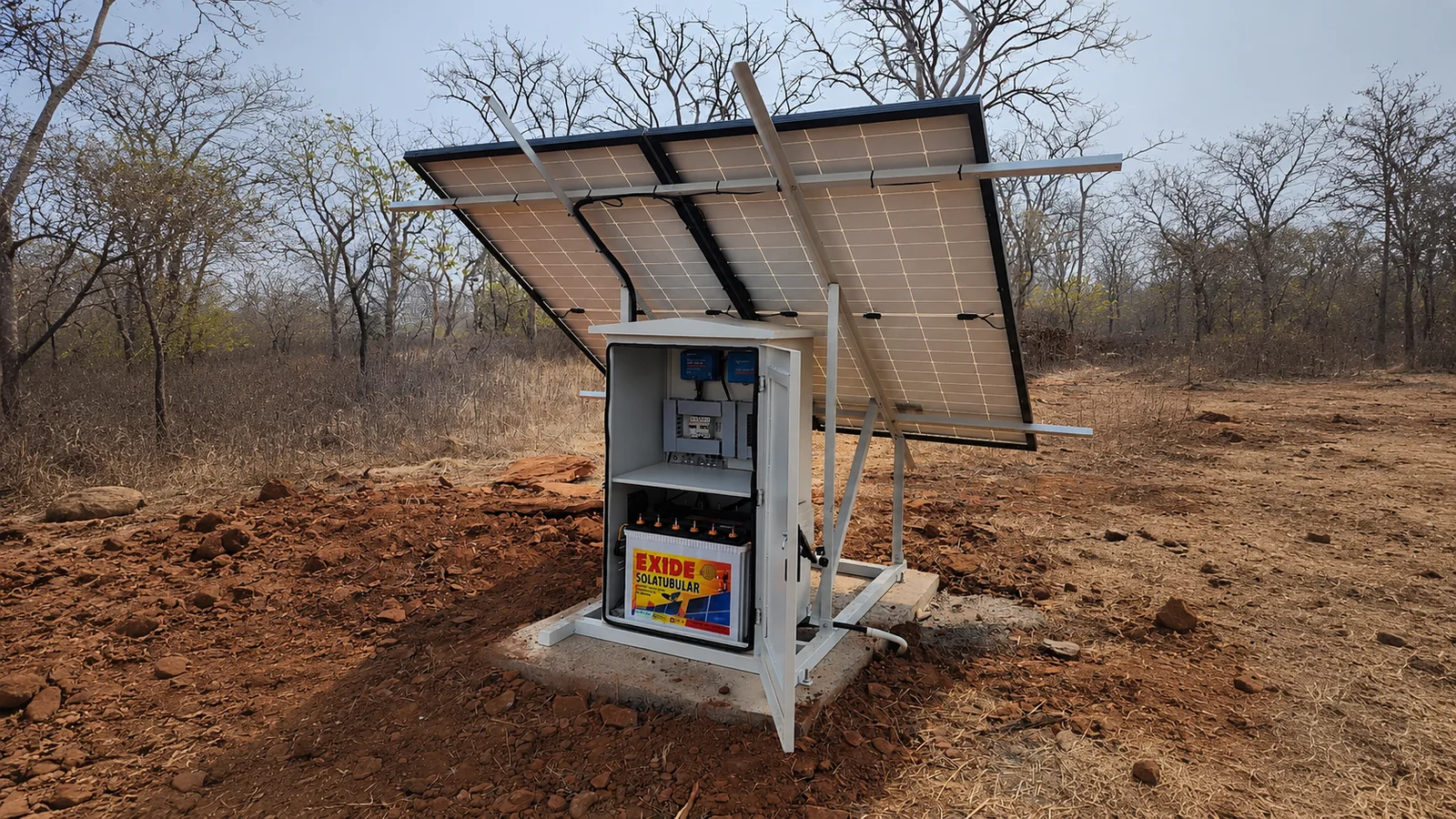 A solar panel array and its control cabinet mounted on a concrete base in dry scrubland, powering a remote surveillance installation.